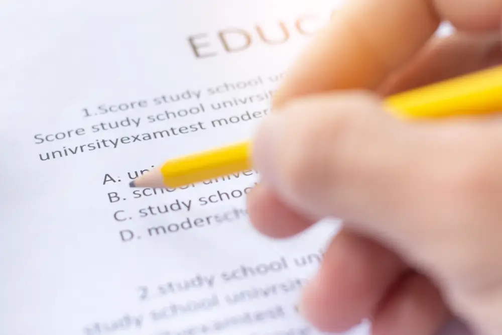 Close-up of a candidate using a yellow pencil to answer questions on a paper-based military entrance exam.