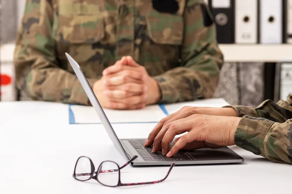 Military recruiter in uniform reviewing test score results with a civilian applicant at a desk