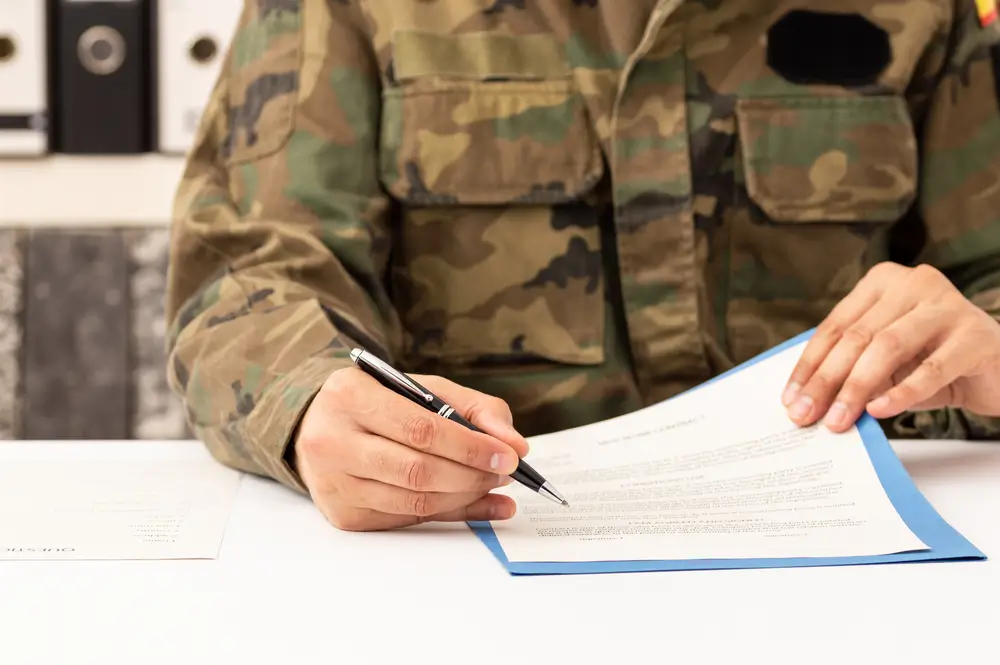 Military recruiter in uniform speaking with civilian applicant at a recruitment office