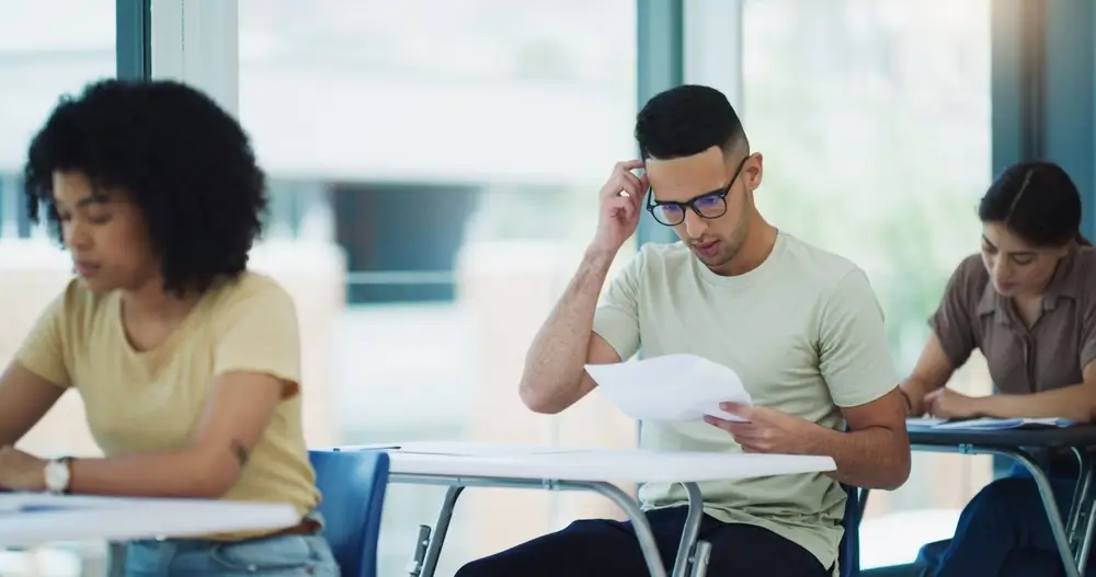 Students sitting in a classroom taking a written aptitude test
