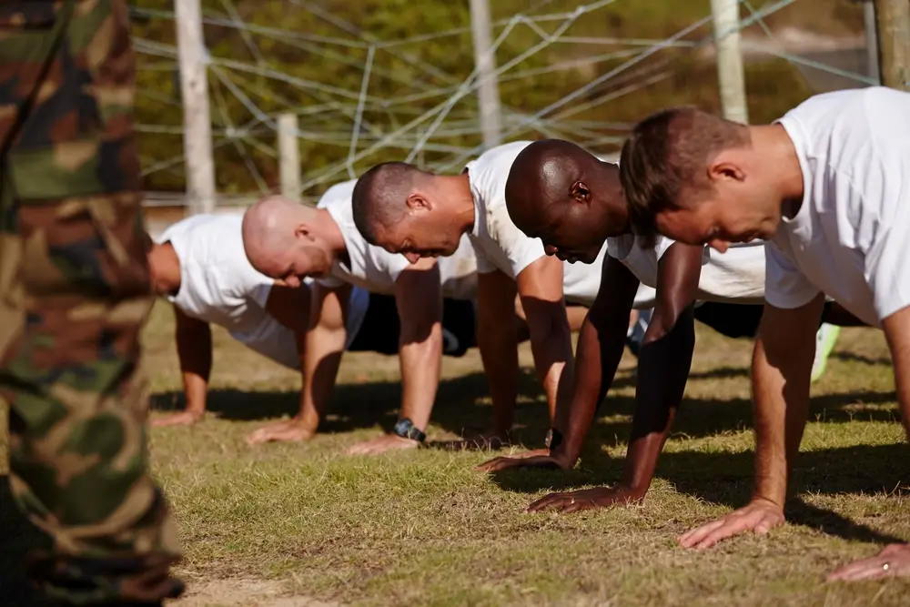 Soldier doing physical fitness training on a military base parade ground in uniform