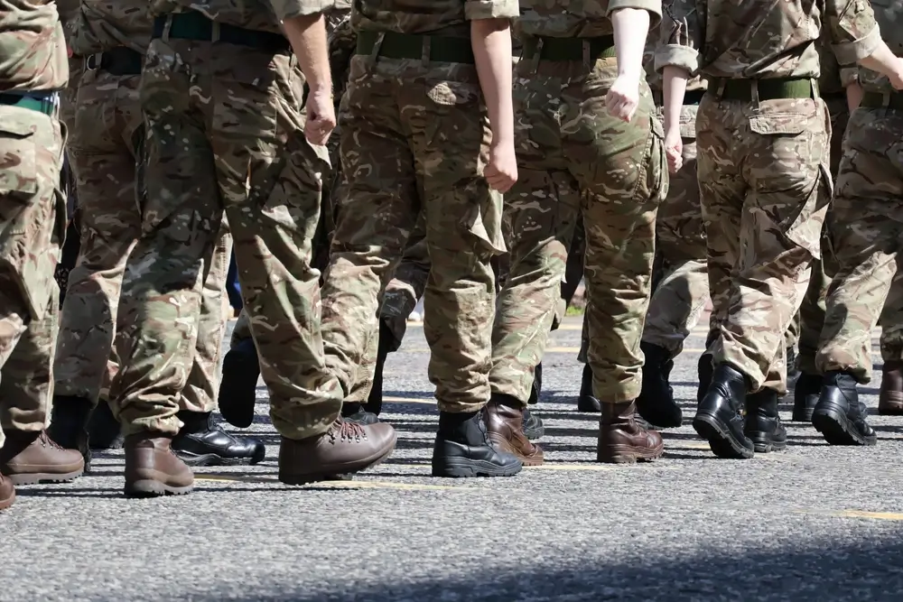 US Army soldiers in uniform standing in formation on a military base parade ground