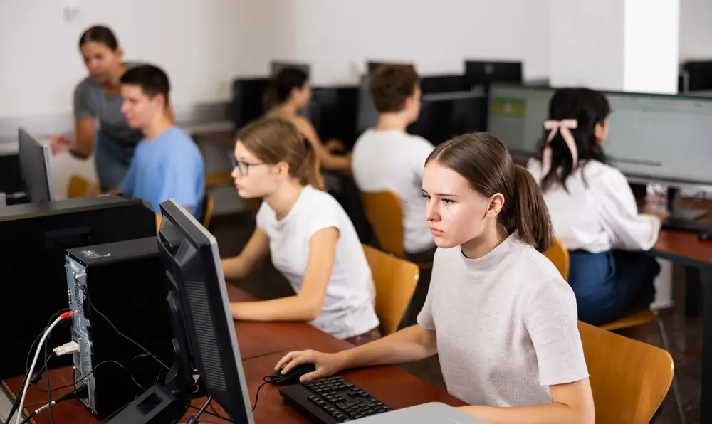 Military recruits seated at computers taking a timed adaptive test at a MEPS facility
