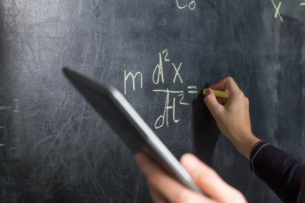 Math equations and geometry formulas written on a whiteboard in a classroom