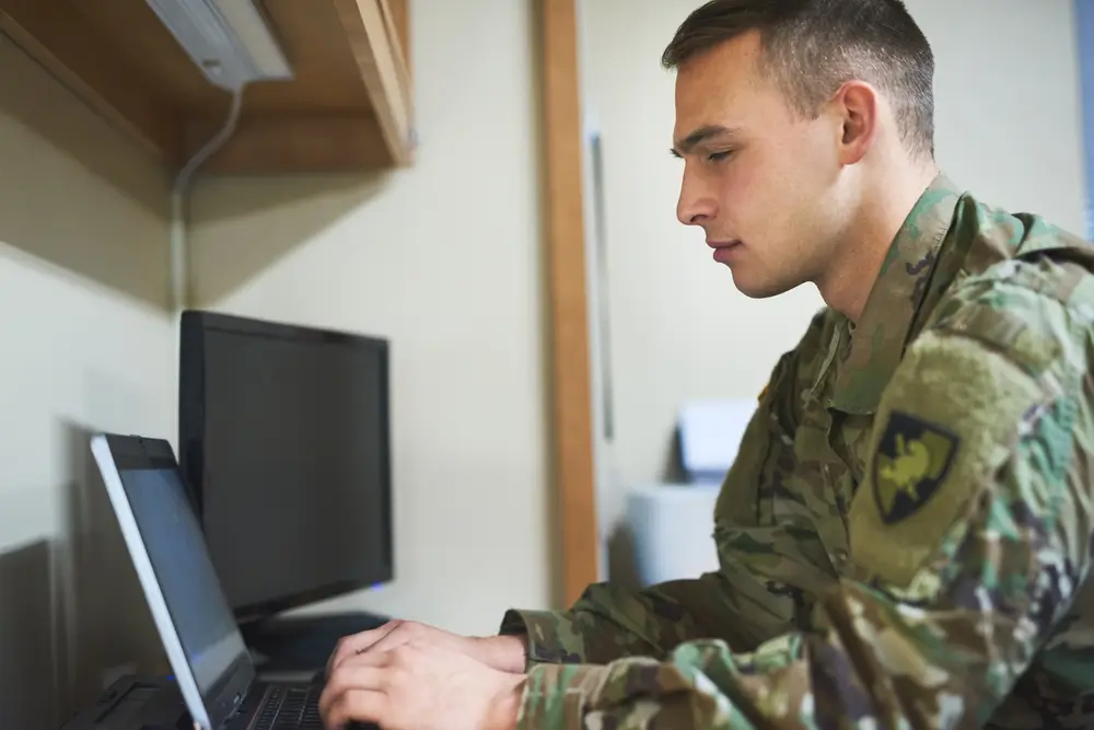Military recruits sitting at computers taking an adaptive exam at a testing center