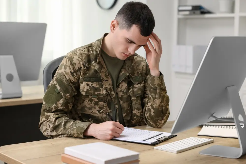 Young man taking a computerized aptitude test at a military testing facility