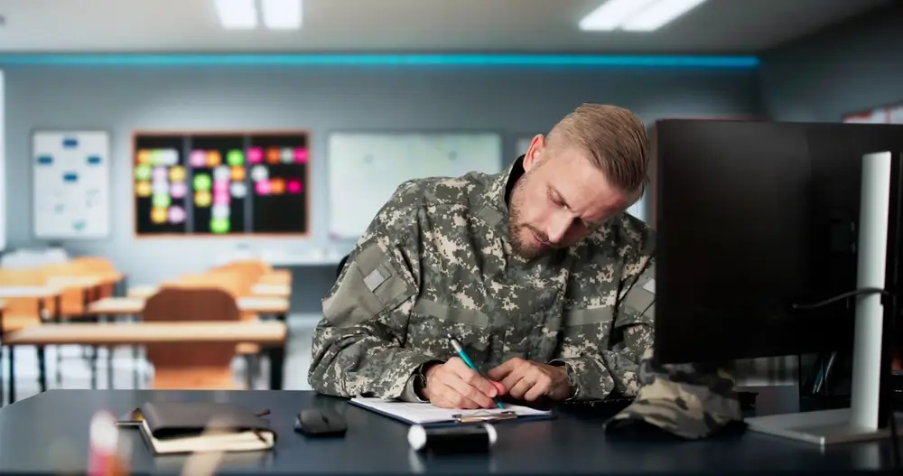 Military recruits taking a written aptitude test at classroom desks