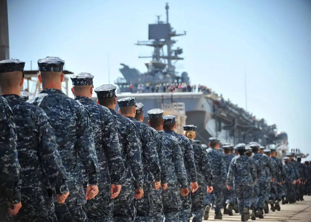 Navy sailors in uniform working on electronics equipment aboard a ship