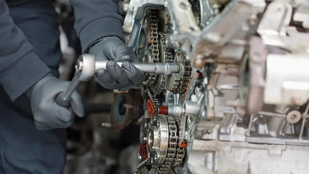 Mechanic using a socket wrench to repair an auto engine, illustrating practical skills for technical subtests.