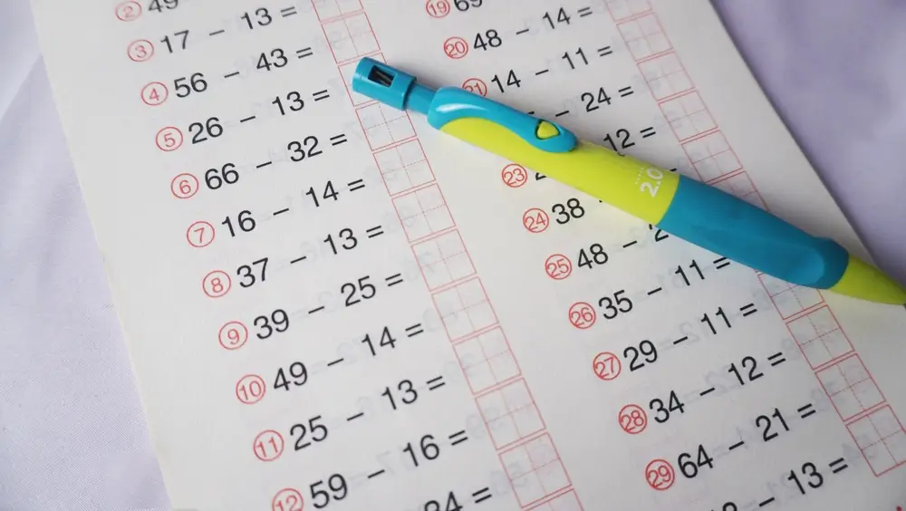 Subtraction problems on a worksheet with a mechanical pencil for a student's timed math practice.