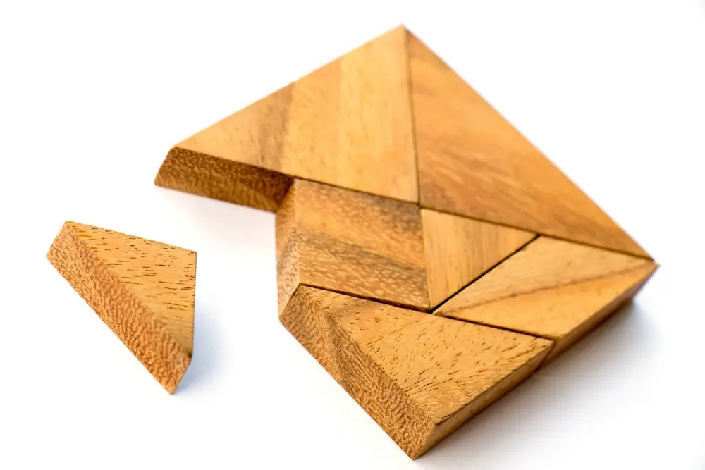 Wooden geometric puzzle pieces for students practicing spatial reasoning and assembling objects during test preparation.